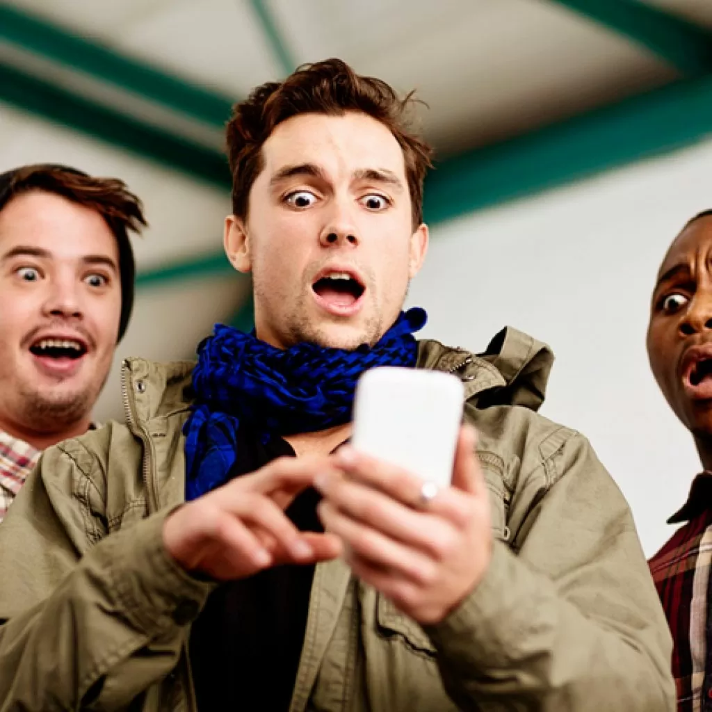 Three young men gaze horrified at image on cellphone; Article 117a